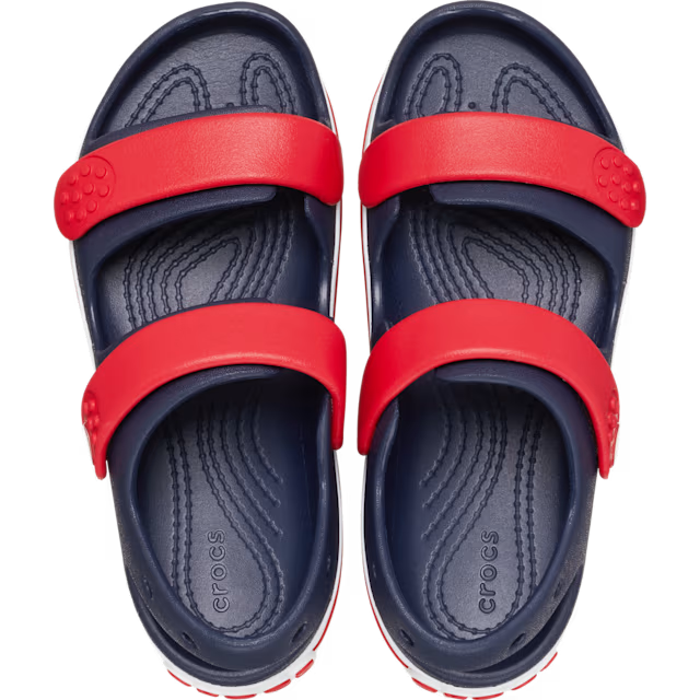 Navy and red Crocs sandals on a white background
