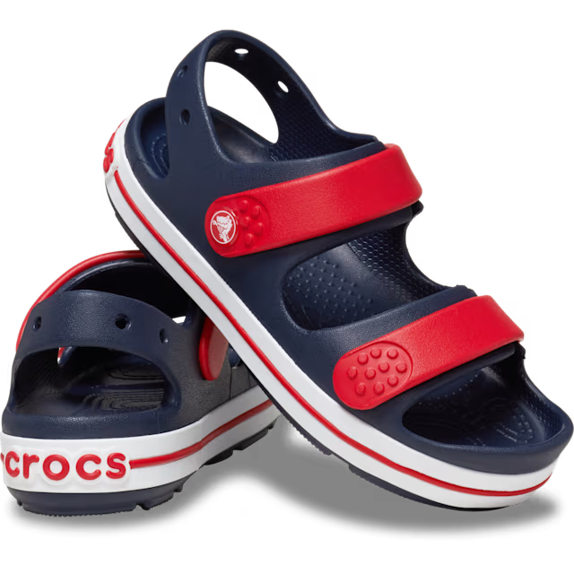 Navy and red Crocs sandals on a white background