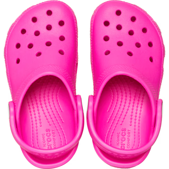 Pair of bright pink clogs on a white background