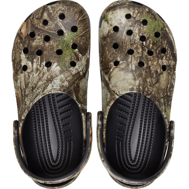 Pair of camouflage clogs with black soles on a white background