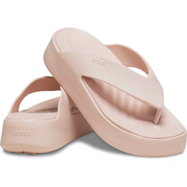 Pair of pink Crocs sandals on a transparent background